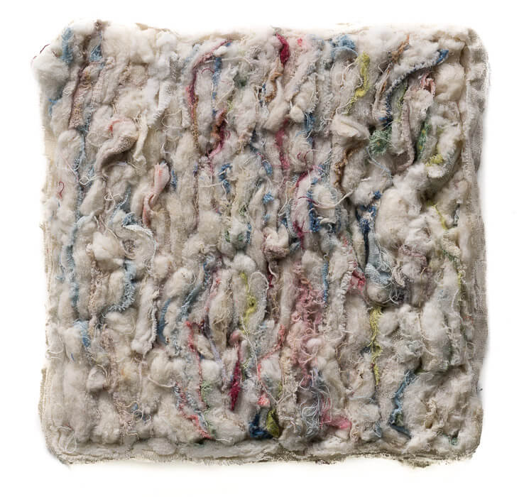 shredded quilt fragments with the cotton showing, colored thread