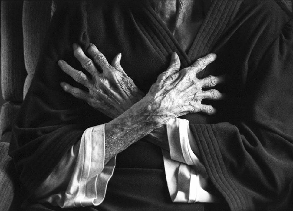 old hands and arms crossed across chest, black and white