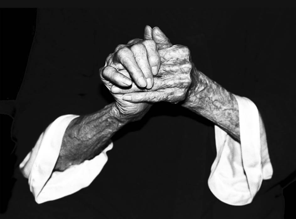 older person, two hands gripping and raised, photograph by Sally Mankus