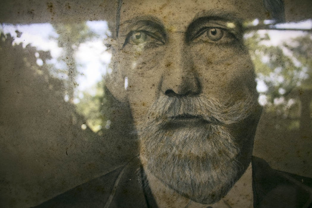 man with a beard, reflections in glass, looking outside