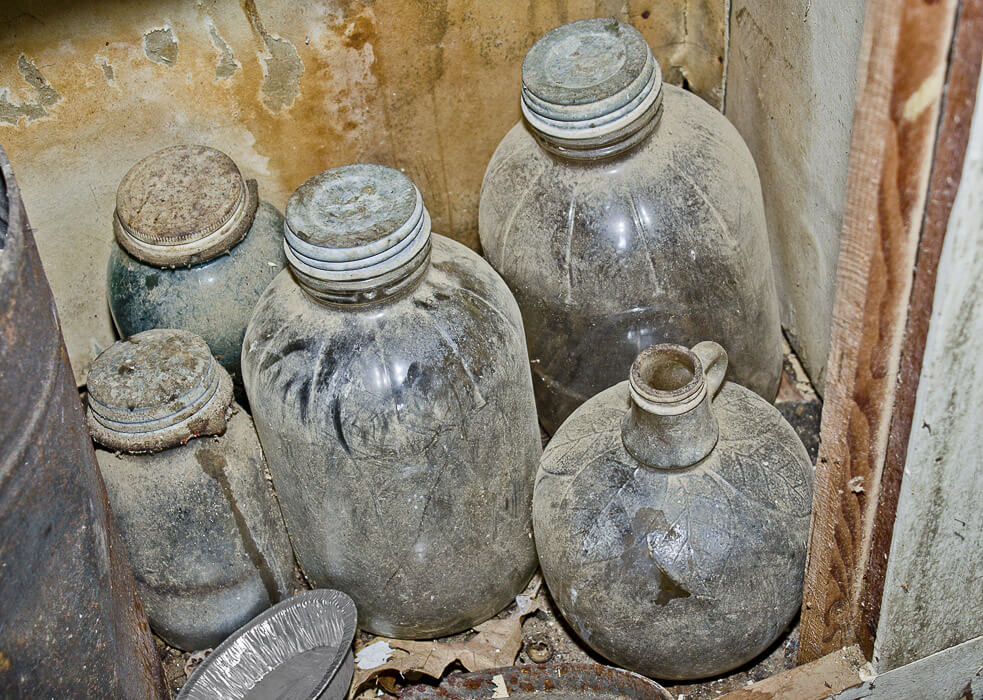 old jars and jugs in a cabinet with dust, rust and stains