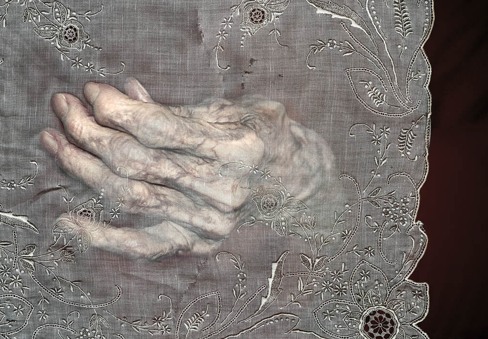 older hand reaching through translucent fabric, digitally manipulated photography