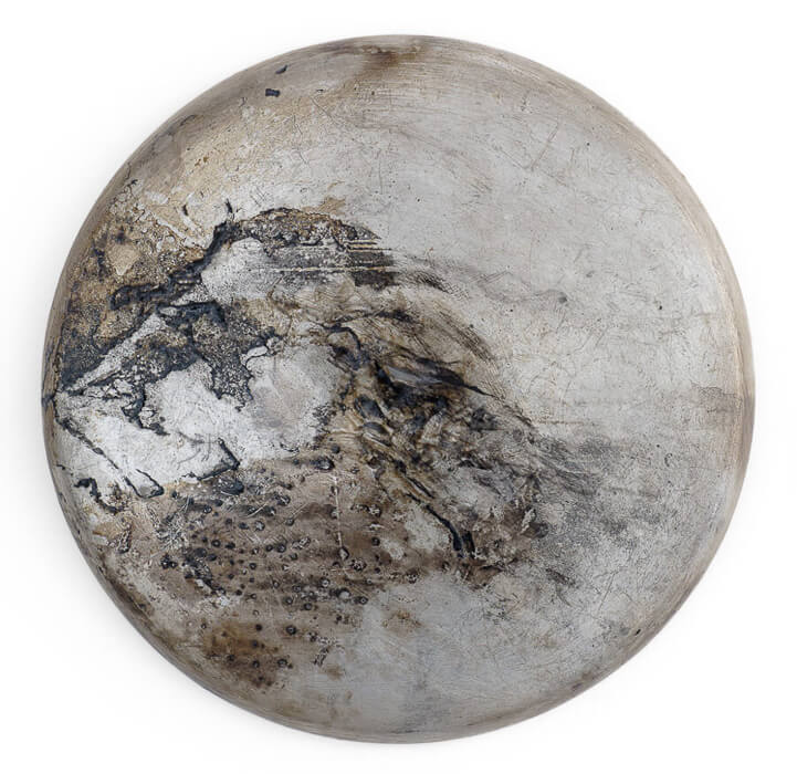 artwork by Sally Mankus, a burnt charred round metal found object, acrylic, charcoal
