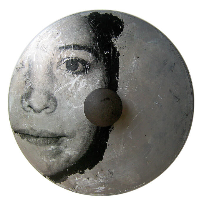 image transfer, face of a women, on scratched metal surface of a found object (a pot lid))