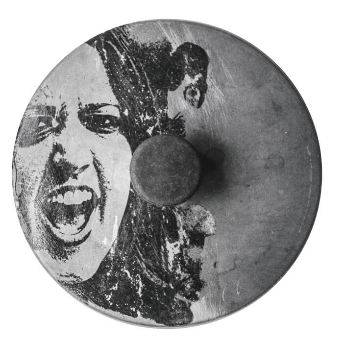 photo transfer, a woman shouting. round metal scratched, stained found object (pot lid with handle)
